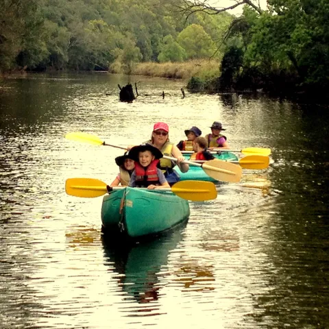 a group of people in a small boat in a body of water