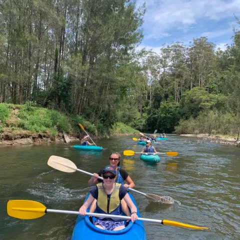 a group of people rowing a boat in the water